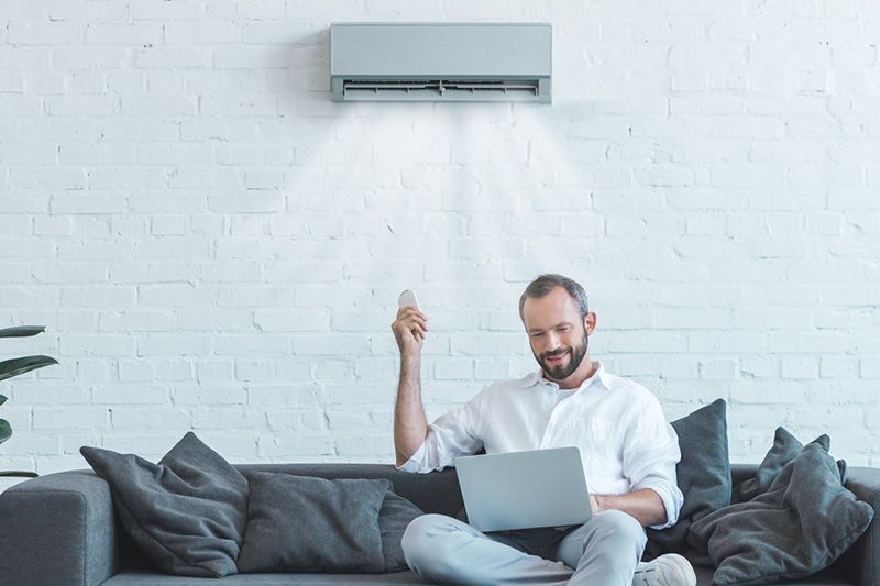 Video - Choose a Ductless System for Your Home Remodel - Man Sits Under Ductless AC