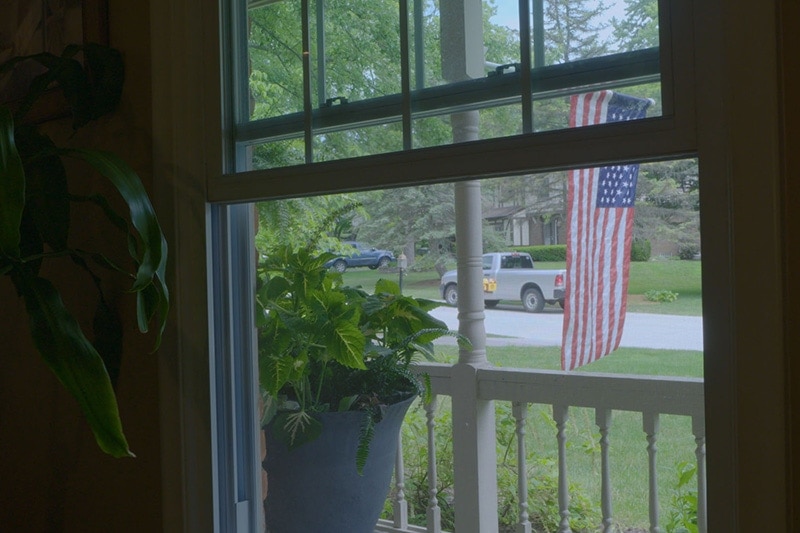 photo of a front yard with a US flag hanging.